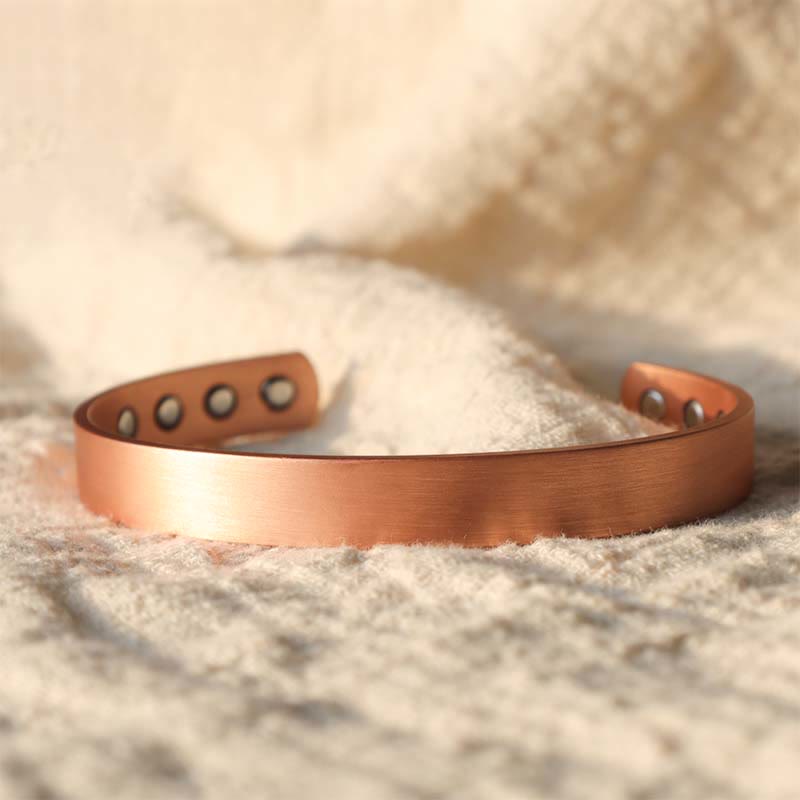 Kupfer Magnetisch Armband mit Löchern auf Sand Nahaufnahme.