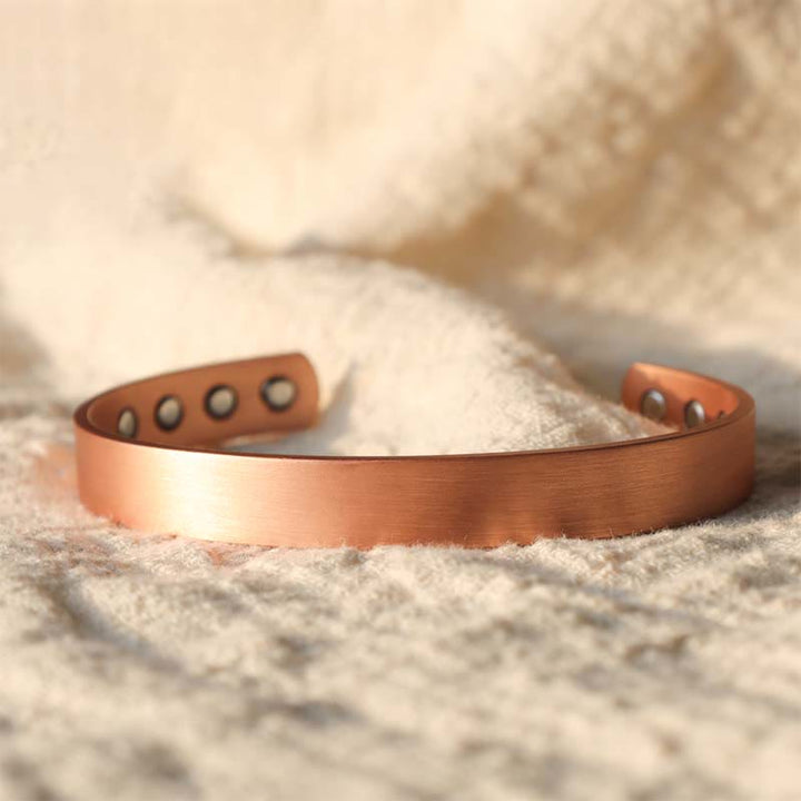 Kupfer Magnetisch Armband mit Löchern auf Sand Nahaufnahme.