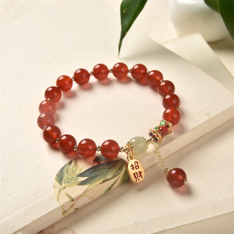Armband Roter Achat Jade mit goldenen Charms auf weißem Untergrund