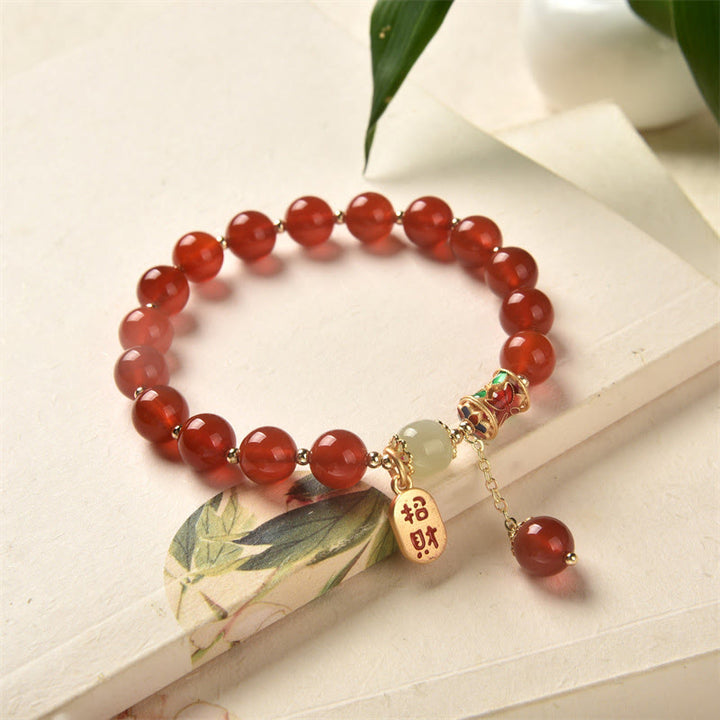 Armband Roter Achat Jade mit goldenen Charms auf weißem Untergrund
