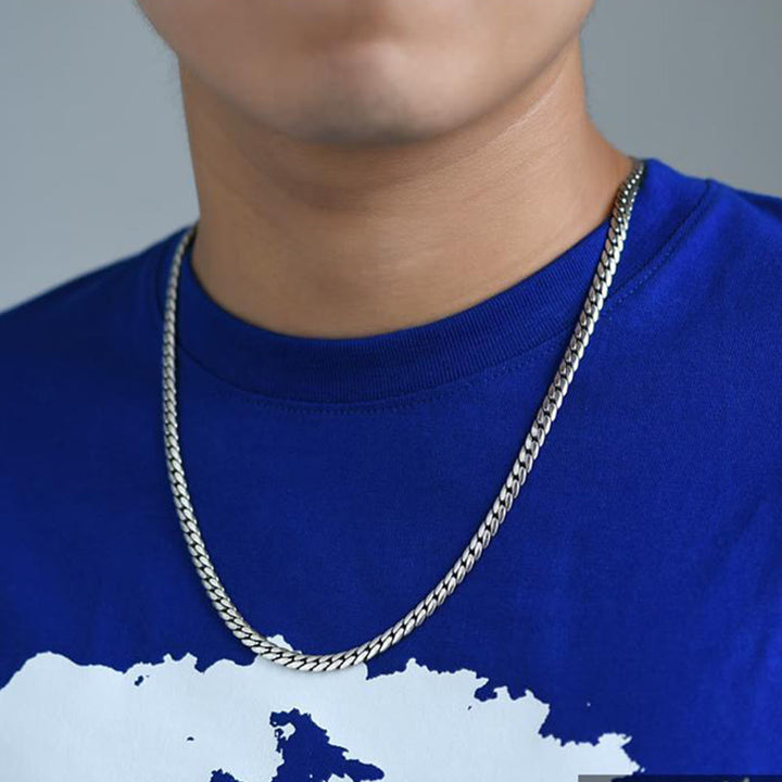 Silberne Gliederkette Halskette an blauem Shirt getragen elegant.