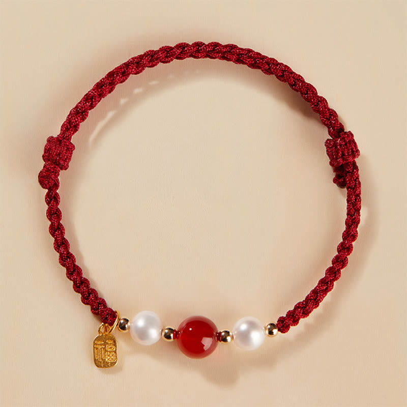 Rotes Armband mit Perlen und Achat-Stein elegant präsentiert.