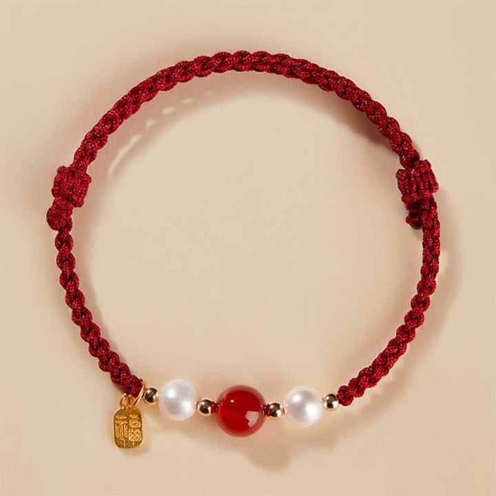Rotes Armband mit Perlen und Achat-Stein elegant präsentiert.