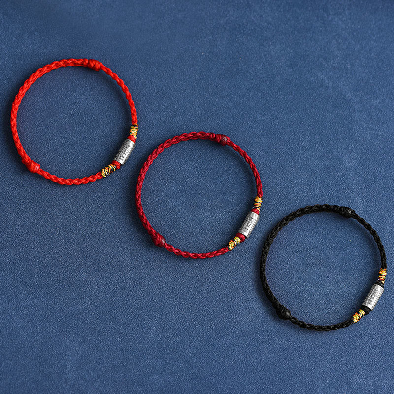 Drei rote und schwarze Armbänder 925 Silber flach arrangiert auf blauem Hintergrund