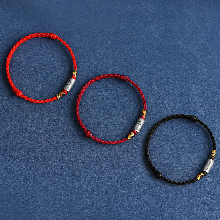 Drei rote und schwarze Armbänder 925 Silber flach arrangiert auf blauem Hintergrund