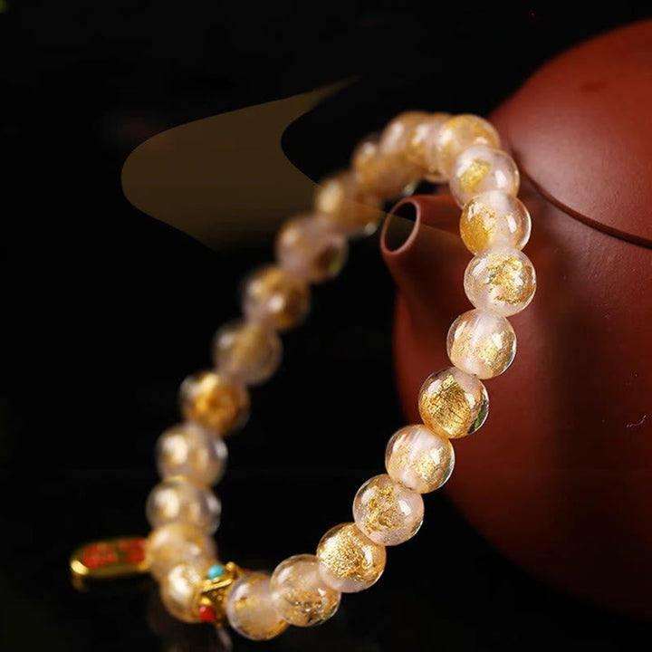 Armband Fu-Zeichen Glück Energie Perlen goldfarben am Handgelenk getragen