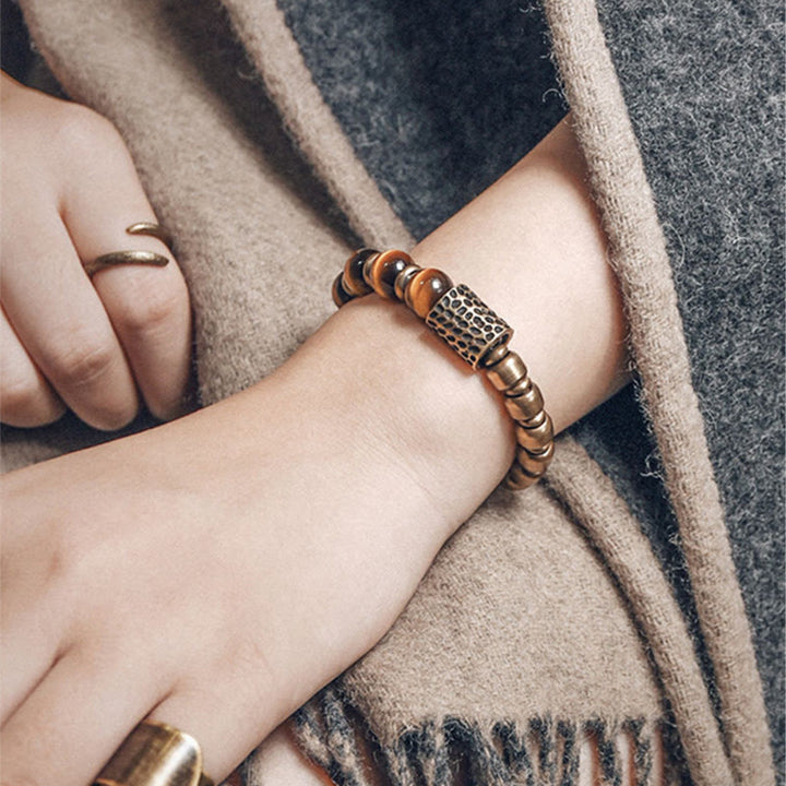 Armband Tigerauge Kupfer am Handgelenk mit goldenem Ring getragen