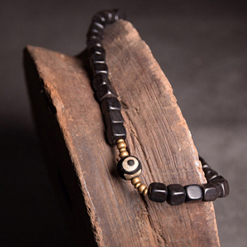 Armband Kupfer Ebenholz Paar mit schwarzen Perlen auf Holz.