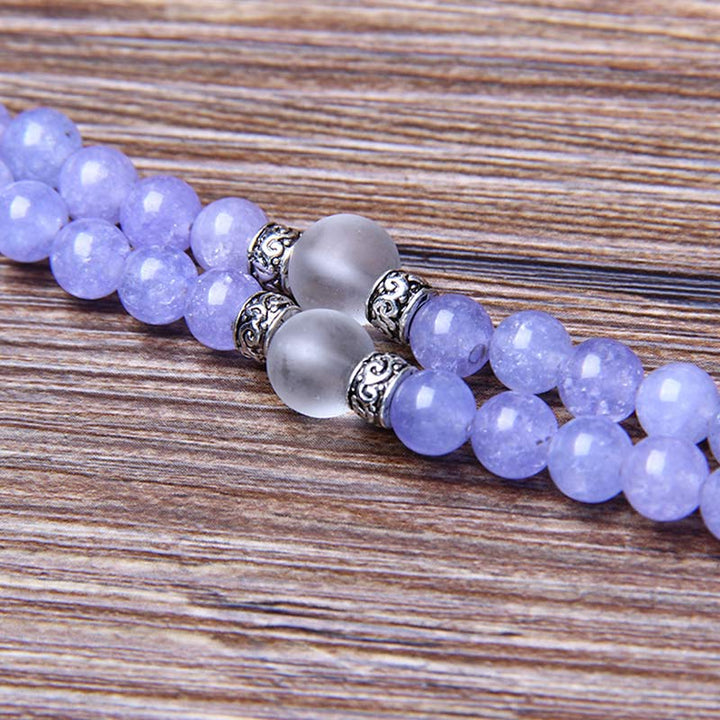 Lila Jaspis Mala Armband mit silbernen Perlen Holzhintergrund.