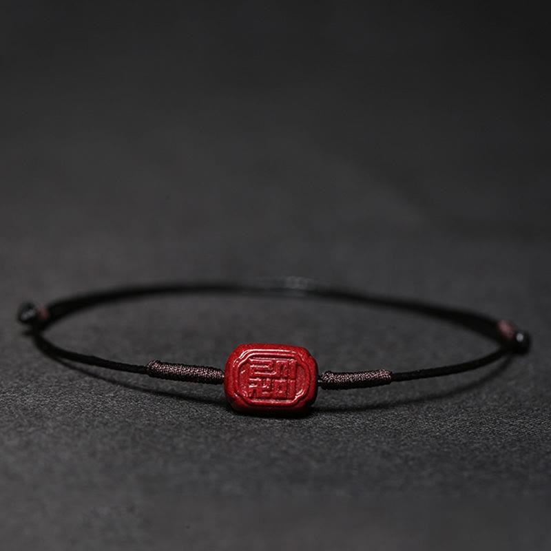 Rotes Zinnober Koi Fisch Armband auf schwarzem Hintergrund Flachaufnahme