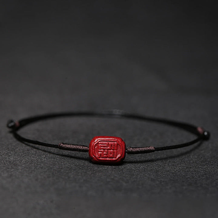 Rotes Zinnober Koi Fisch Armband auf schwarzem Hintergrund Flachaufnahme