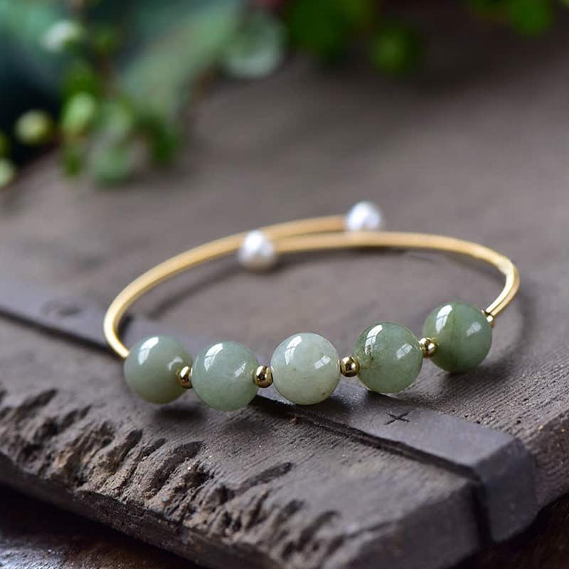 Armband Jade – Glück & Fülle mit grünen Steinen auf Holz Nahaufnahme