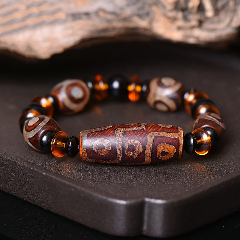 Tibetisches Armband mit Dzi Perlen und bernsteinfarbenen Steinen, Retro-Design elegant präsentiert.
