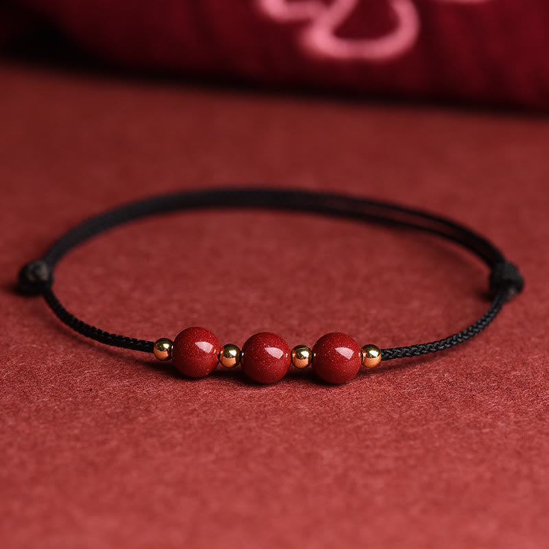Rotes Zinnober Armband mit Glücksperlen auf rotem Hintergrund Flatlays