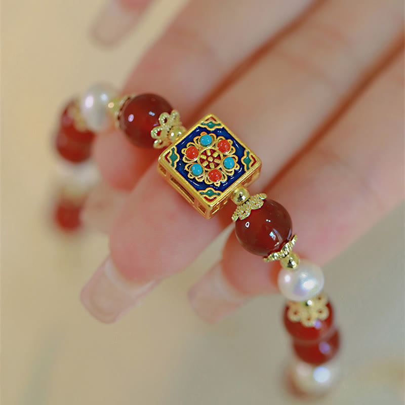 Armband Roter Achat Perle mit vergoldetem Emaille Zentrum am Handgelenk.