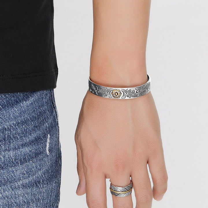 Silbernes Armband mit Ornamenten und passendem Ring getragen.