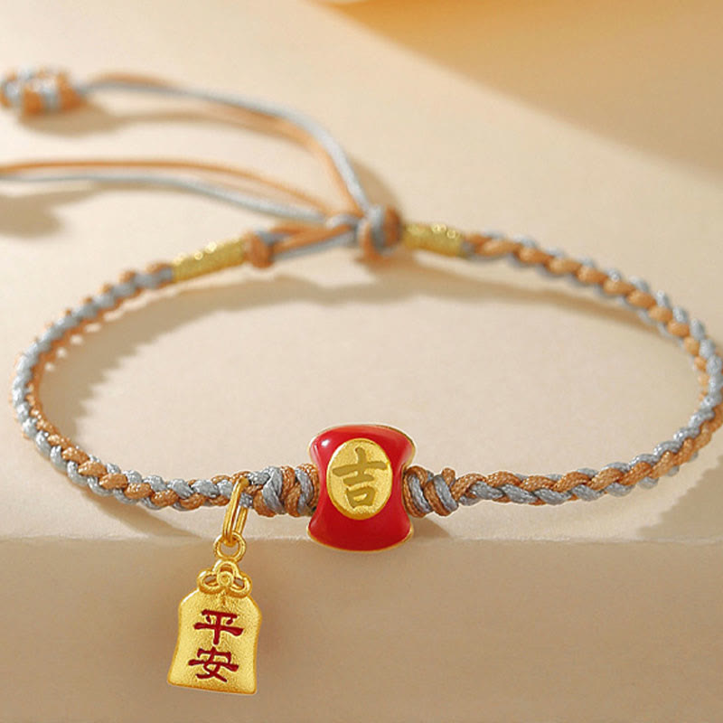 Rotes Glücksbringend Armband mit goldenen Anhängern elastisch getragen.