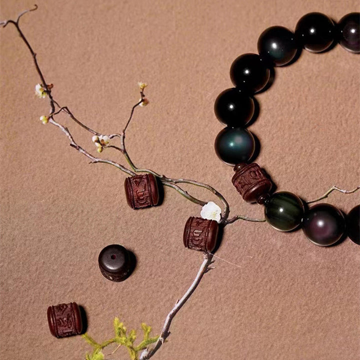 Obsidian Armband mit Perlen und Holzelementen auf neutralem Hintergrund