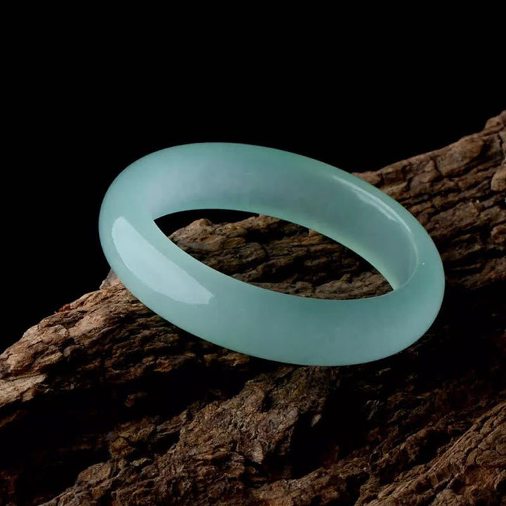 Hellblaues Jade Armband auf Holz, glänzend und elegant