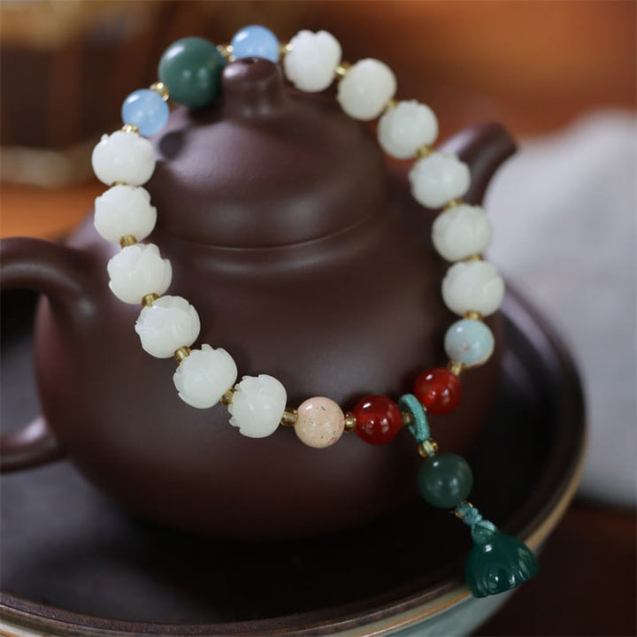 Bodhi Lotus Armband mit weißen Perlen und grünem Stein elegant.