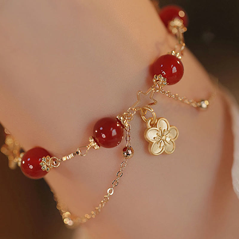 Armband Roter Achat Stern – Ruhe mit goldenen Blütenanhängern am Handgelenk