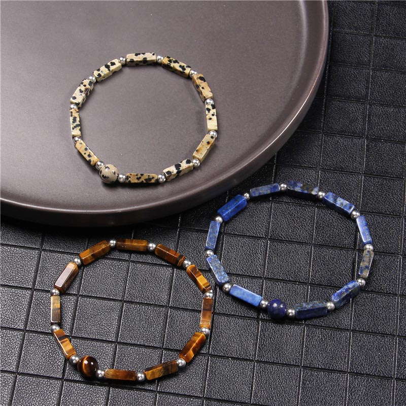 Drei Armbänder Tigerauge Amethyst auf schwarzem Untergrund Flat Lay