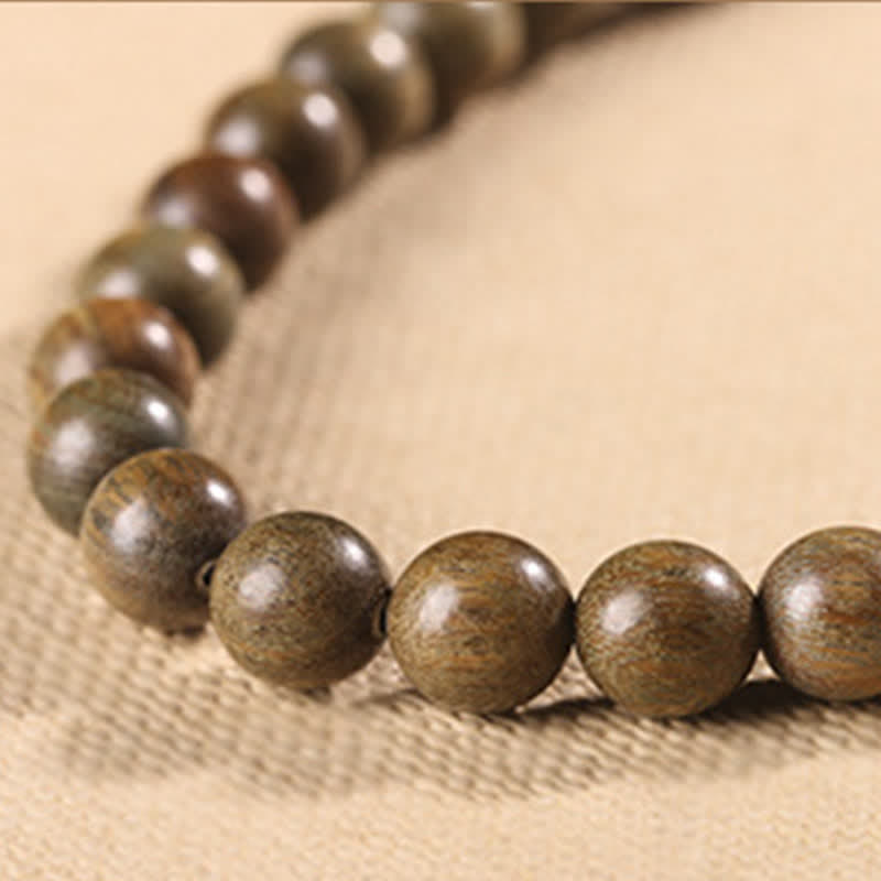 Armband Sandelholz Kristall braune Perlen auf beigem Stoff