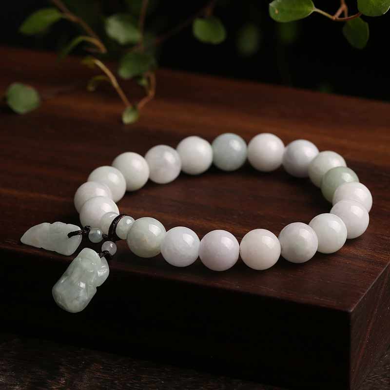 Weißes Jade Pixiu Armband mit Anhänger auf Holzoberfläche.