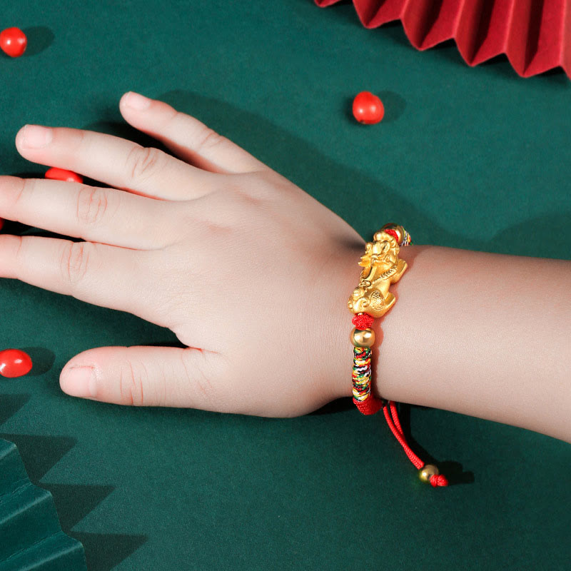 Goldenes Pixiu Armband mit roten Perlen am Handgelenk getragen