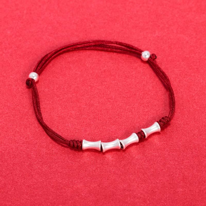 Rotes Armband mit Bambus-Silber-Perlen elastisch getragen Schutz Glück