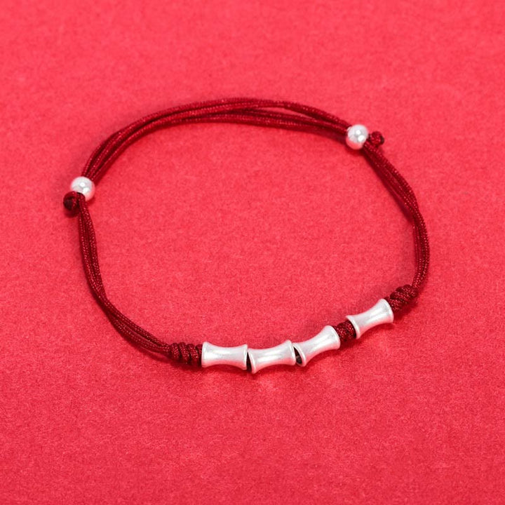 Rotes Armband mit Bambus-Silber-Perlen elastisch getragen Schutz Glück