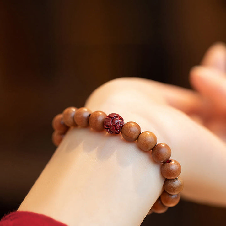 Armband Zinnober Lotus am Handgelenk getragen Holzperlen elastisch Glück