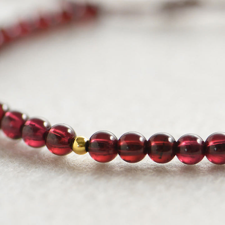 Armband Granat rote Perlen goldene Akzente Stabilität Eleganz.