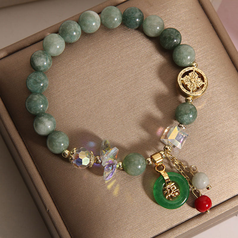 Armband mit grüner Jade, Erdbeerquarz und goldenen Anhängern elegant.