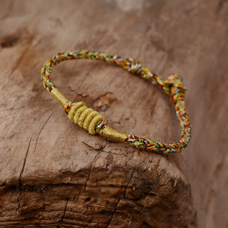 Buntes geflochtenes Armband mit Knoten auf Holz Schutz