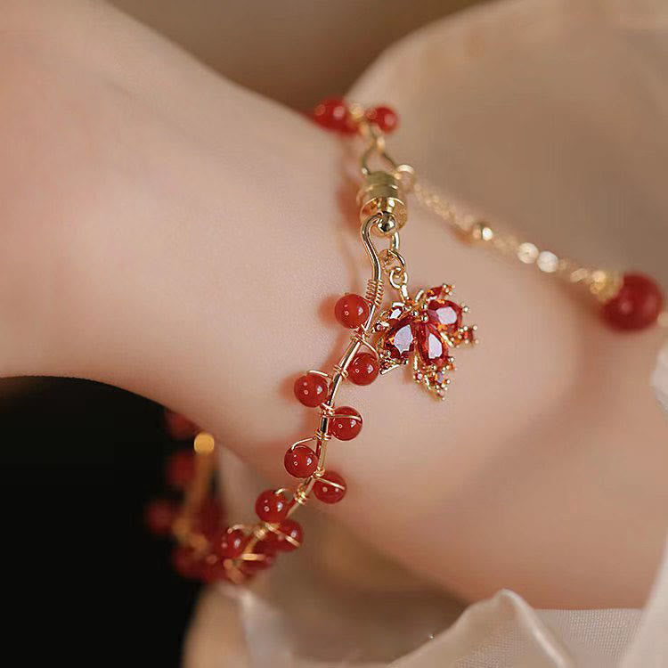 Rotes Armband mit Ahornblatt Charm Glücksanhänger elegant getragen
