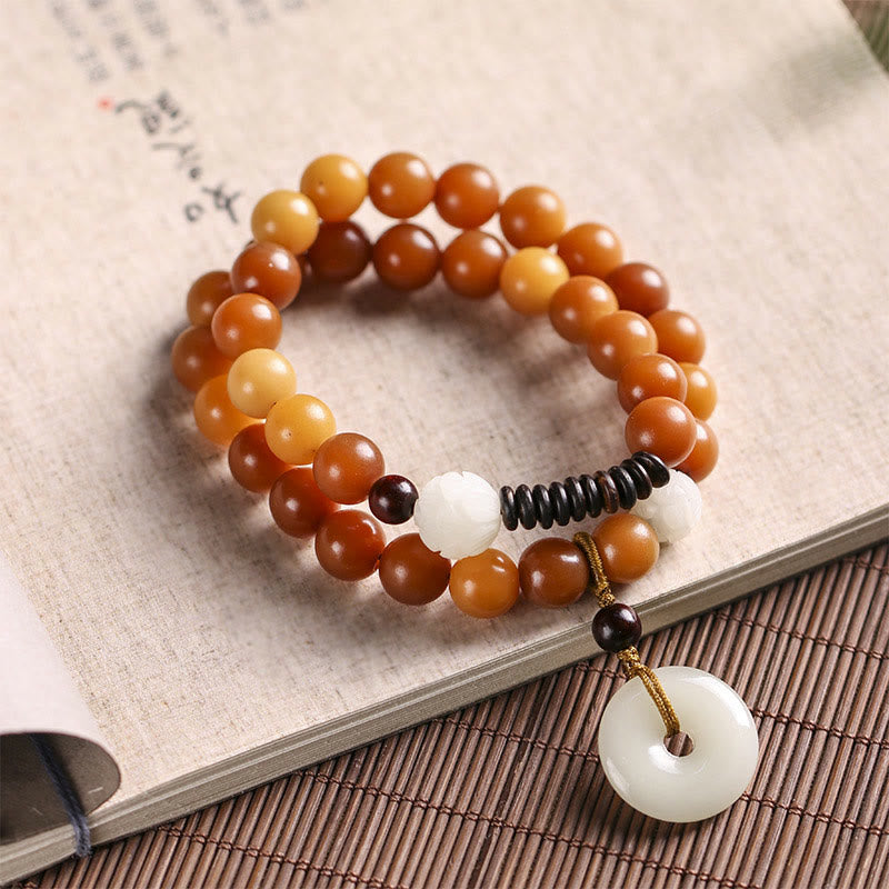 Bodhi Jade Lotus Armband mit braunen Perlen und weißem Anhänger elegant.