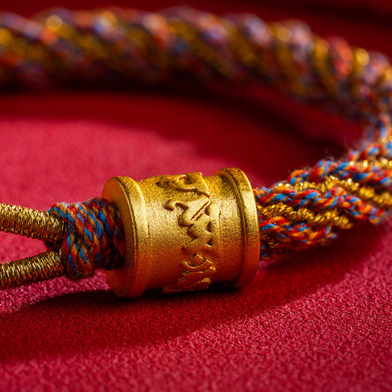 Armband Om Mani Padme Hum Multicolored mit goldenem Verschluss auf rotem Stoff.