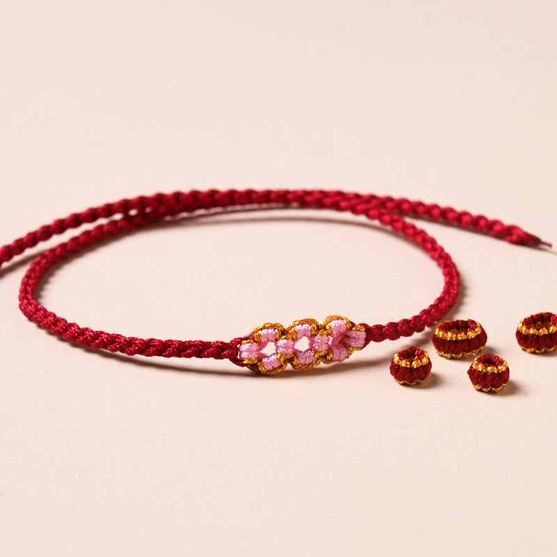 Rotes Armband Pfirsichblüte – Schutz mit rosa Perlen elegant.