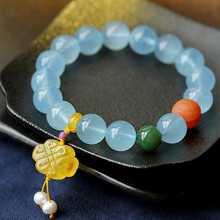 Armband Aquamarin – Frieden mit hellblauen Steinen und goldenem Anhänger.