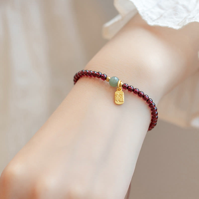 Armband Erdbeerquarz Granat Fu-Zeichen am Handgelenk getragen elegant