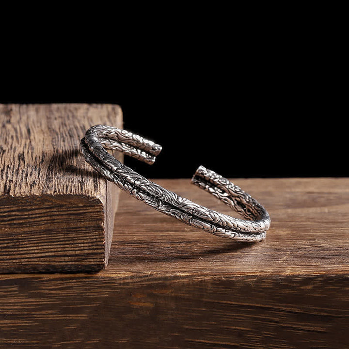 Silbernes Drachen-Armband auf Holz, elegantes Schmuckstück Balance-Design.