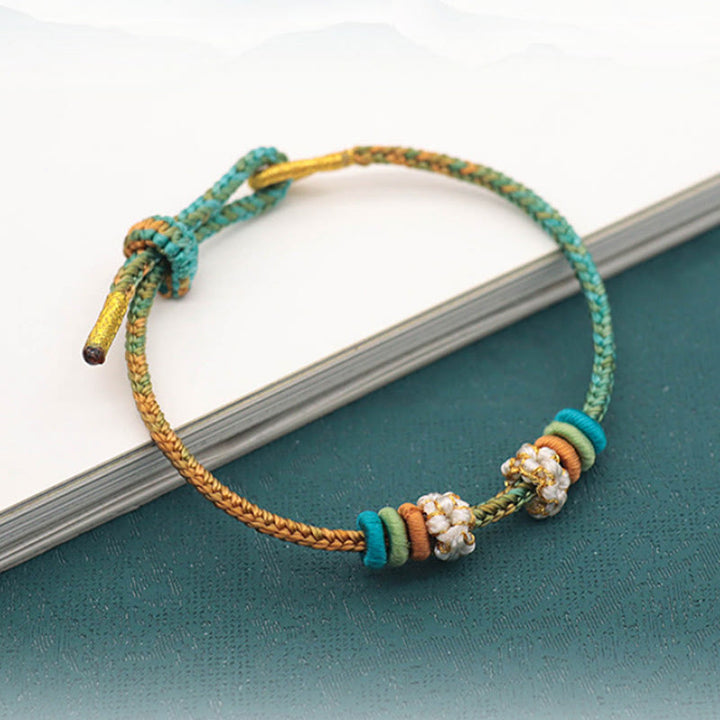 Armband Pfirsichblüte Glück Frieden grüne Schnur Perlendetails elegant