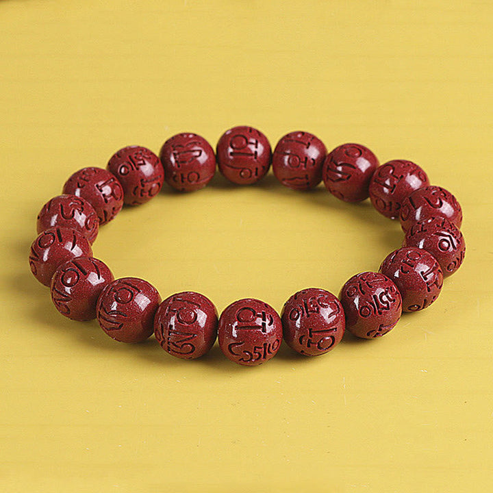 Rotes Zinnober Armband mit Om Mani Padme Hum Gravur elastisch getragen
