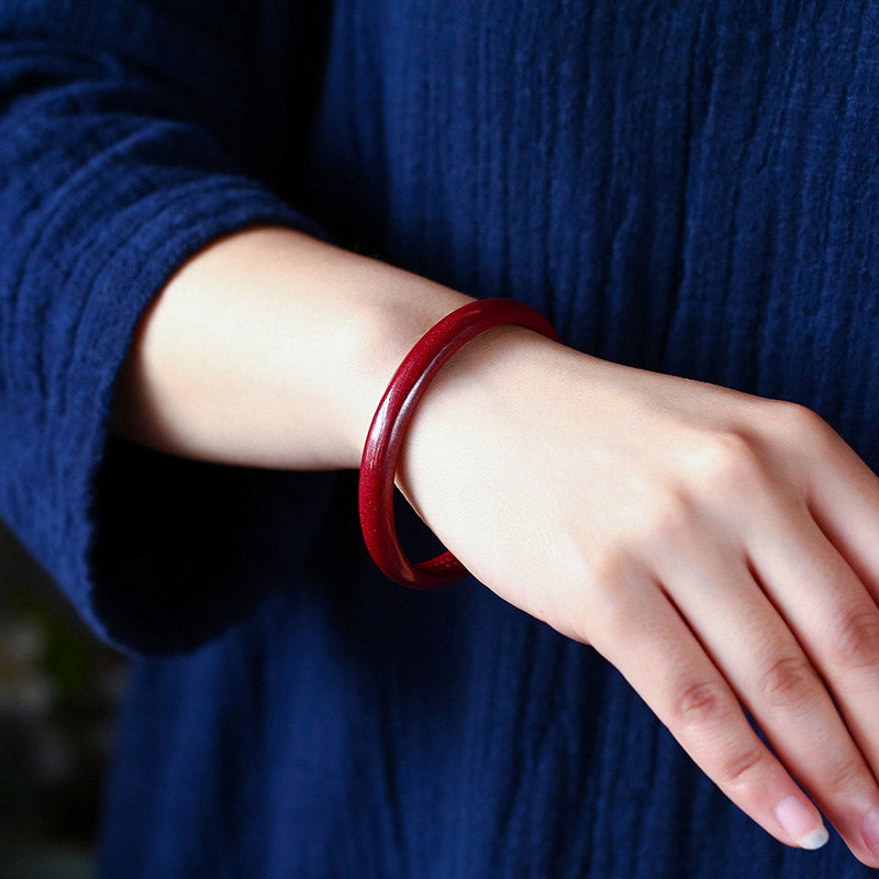 Rotes Armband Zinnober Herzsutra Segen am Handgelenk getragen elegant