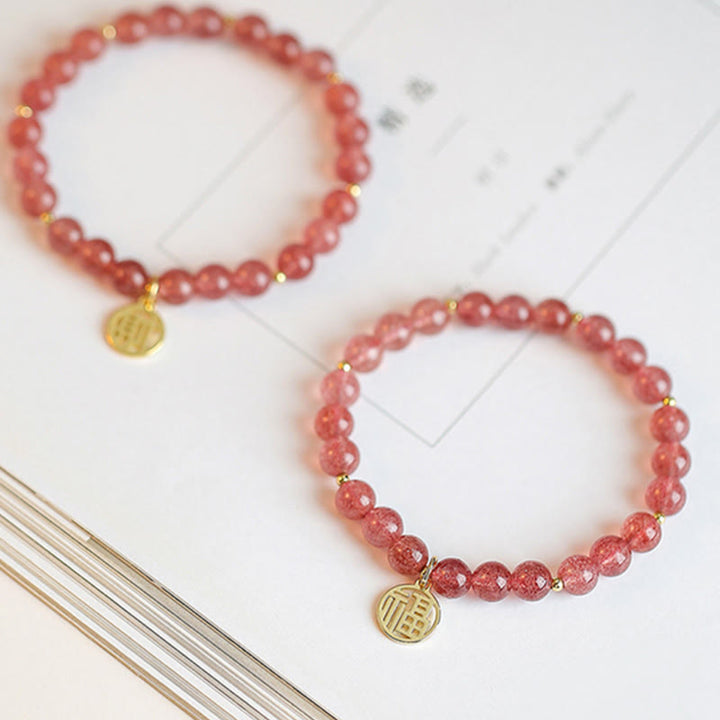 Armband Erdbeerquarz Fu-Zeichen Heilung rosé Perlen Goldakzente elastisch