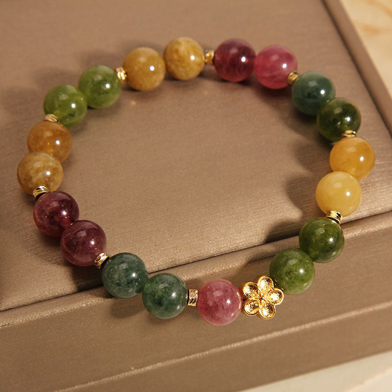 Bunt Tourmaline Armband mit goldener Blume Charm elegant gestylt.