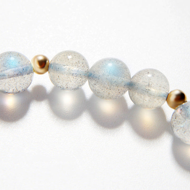 Armband mit Mondstein und goldfarbenen Perlen, elegantes Design.