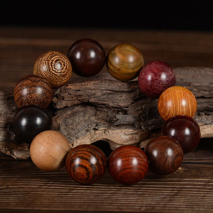 Armband Sandelholz – Schutz & Heilung mit bunten Holzperlen auf Ast.