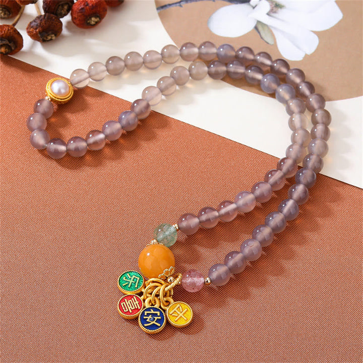 Lila Achat Armband mit goldenen Charms und orange Stein